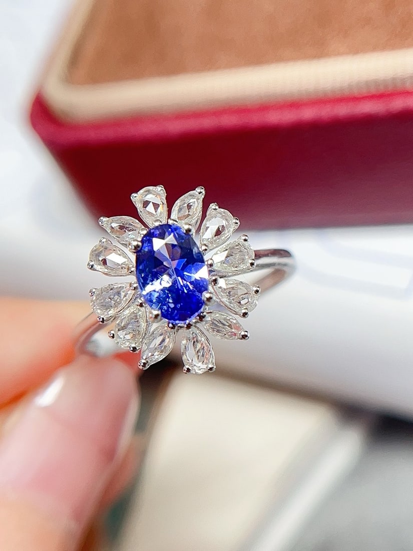 18K Gold Flawless Tanzanite Ring: This ring is meticulously crafted in 18K gold, featuring a flawless glassy tanzanite that exudes unparalleled elegance. The addition of white sapphires enhances its splendor, with a design that is bot