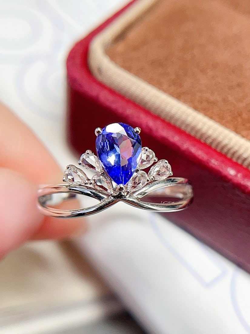 18K Gold Flawless Tanzanite Ring: This ring is meticulously crafted in 18K gold, featuring a flawless glass-like tanzanite, exuding an aura of elegance and nobility. The main stone is approximately 0.6 carats, complemented by 6 white 