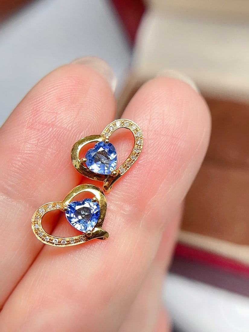 18K Gold Sapphire Earrings: These earrings are crafted in 18K gold, featuring heart-shaped sapphires that exude a captivating brilliance. Surrounded by 22 diamonds, they add a touch of luxury. The overall design is fresh and swe