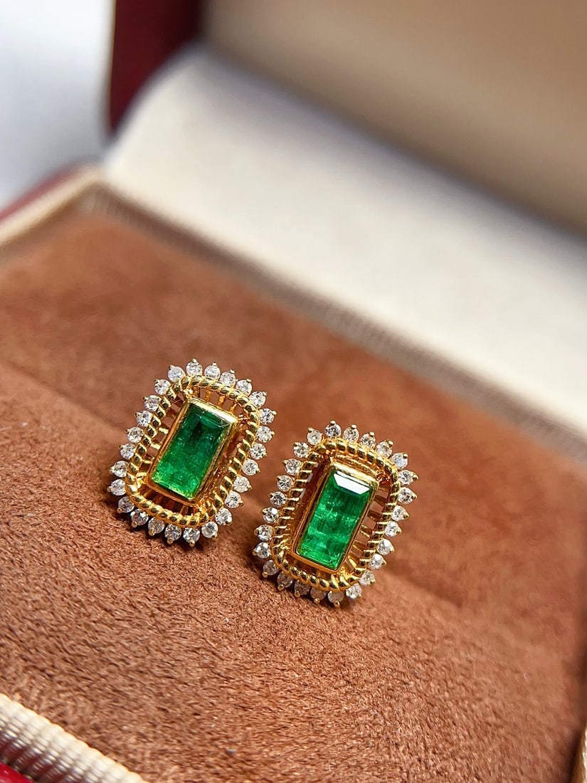 18K Gold Emerald Earrings: These earrings are crafted from 18K gold, set with richly colored emeralds, showcasing a classic design. The elegant luster exudes a noble aura when worn. The earrings are also adorned with multiple d