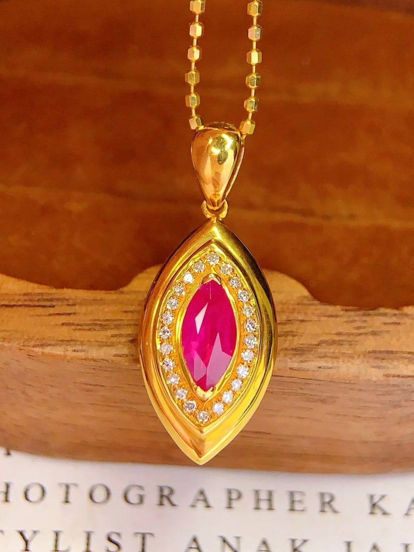 18K Gold Natural Ruby Pendant: This pendant is meticulously crafted in 18K gold, set with a natural ruby that exudes a captivating brilliance. The rich hue of the ruby is complemented by 24 diamonds, showcasing luxury. Suitable for