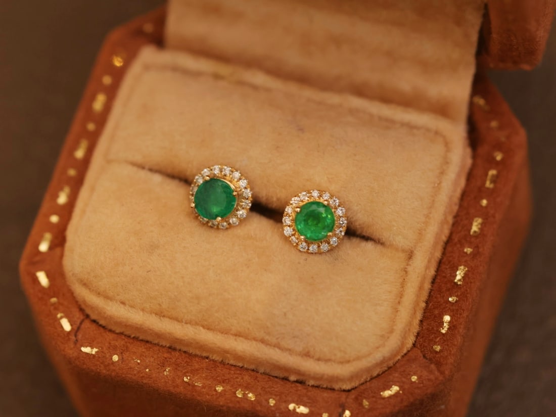 18K Gold Emerald Earrings: These earrings are meticulously crafted in 18K gold, surrounded by a circle of brilliant diamonds, showcasing the unique charm of emeralds. The overall design is elegant and exudes extraordinary textu