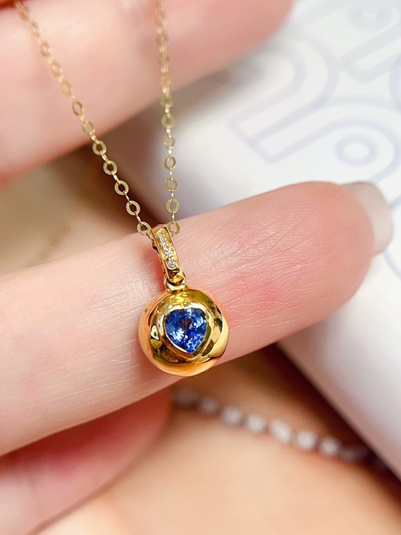 18K Gold Sapphire Collarbone Necklace: This 18K gold collarbone necklace features a heart-shaped sapphire as the centerpiece, showcasing a charming cornflower hue. The brilliant fire is complemented by a delicate gold bead design, making t