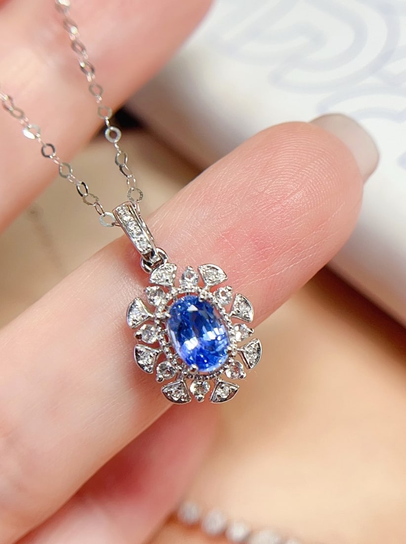 18K Gold Sapphire Pendant: This pendant features a dazzling sapphire set in 18K gold, exuding a captivating brilliance. The sapphire's vitreous texture complements its cornflower hue. Accompanied by 13 diamonds and 8 white sapp