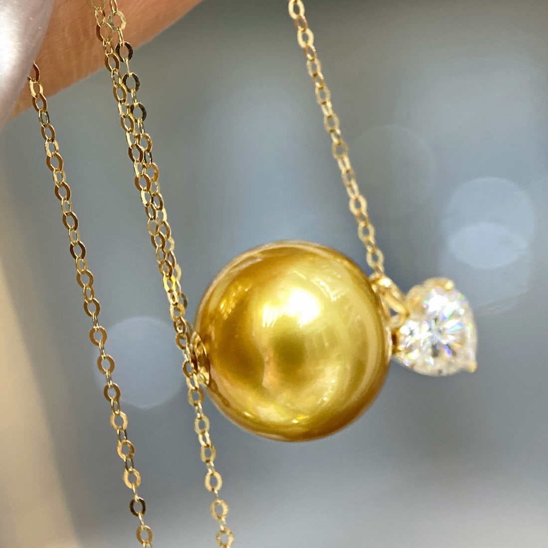 18K Gold Natural Pearl Pendant: This jewelry set features nearly round pearls measuring 12-13mm, with slight blemishes and a super rich golden hue. It is complemented by an 18K gold setting with moissanite heart design, exuding eleg