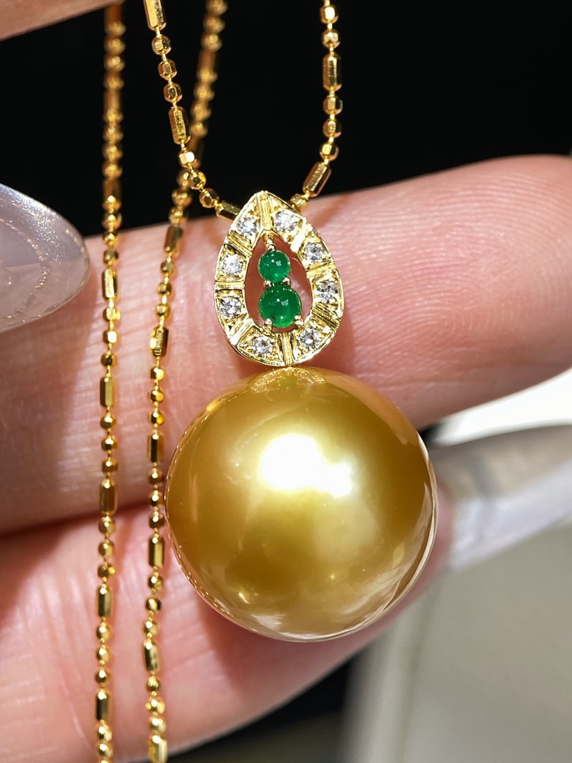 18K Gold Natural Pearl Pendant: Exquisitely crafted from 18K gold and featuring a natural emerald, this pearl pendant exudes an air of noble elegance. The emerald boasts a rich, vibrant hue, while diamond accents add a touch of luxu