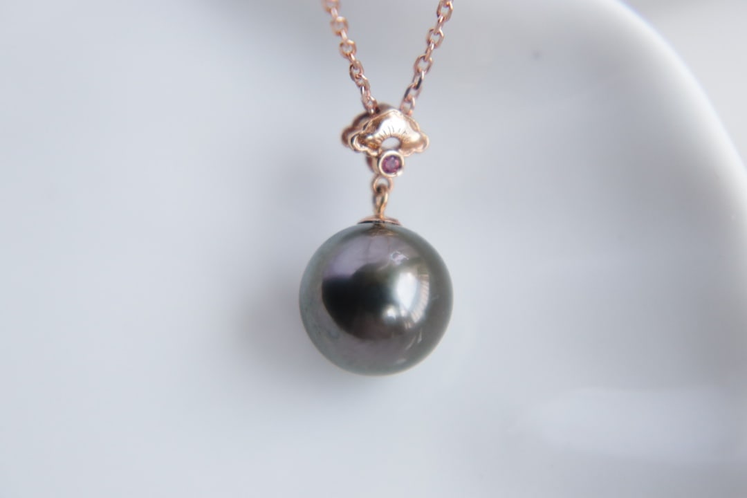 18K Gold Tahitian Pearl Pendant: This pendant is crafted from 18K gold and features a Tahitian pearl with a diameter of 9.8mm, showcasing enchanting luster and overtones. The pearl has minor blemishes at the bottom, which do not affe