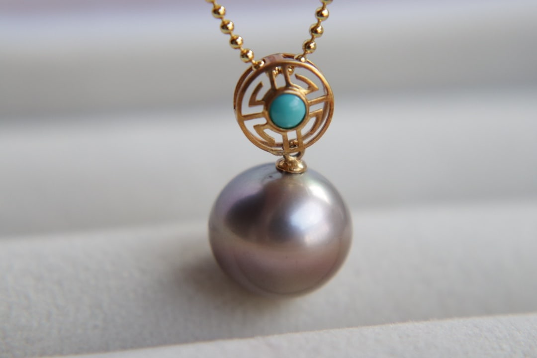 18K Gold Tahitian Pearl Pendant: This pendant is crafted from 18K gold, featuring a Tahitian pearl with a diameter of 12.8mm. The pearl is perfectly round with a strong luster and flawless surface, showcasing its natural elegance. (P