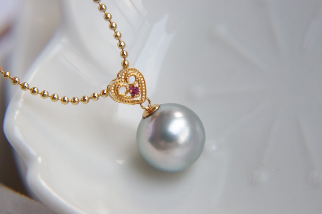 18K Gold Tahitian Pearl Pendant: This pendant is crafted from 18K gold, featuring a Tahitian pearl that showcases its natural luster and flawless quality. The pearl measures 11mm in diameter, exuding a strong shine that captivates th