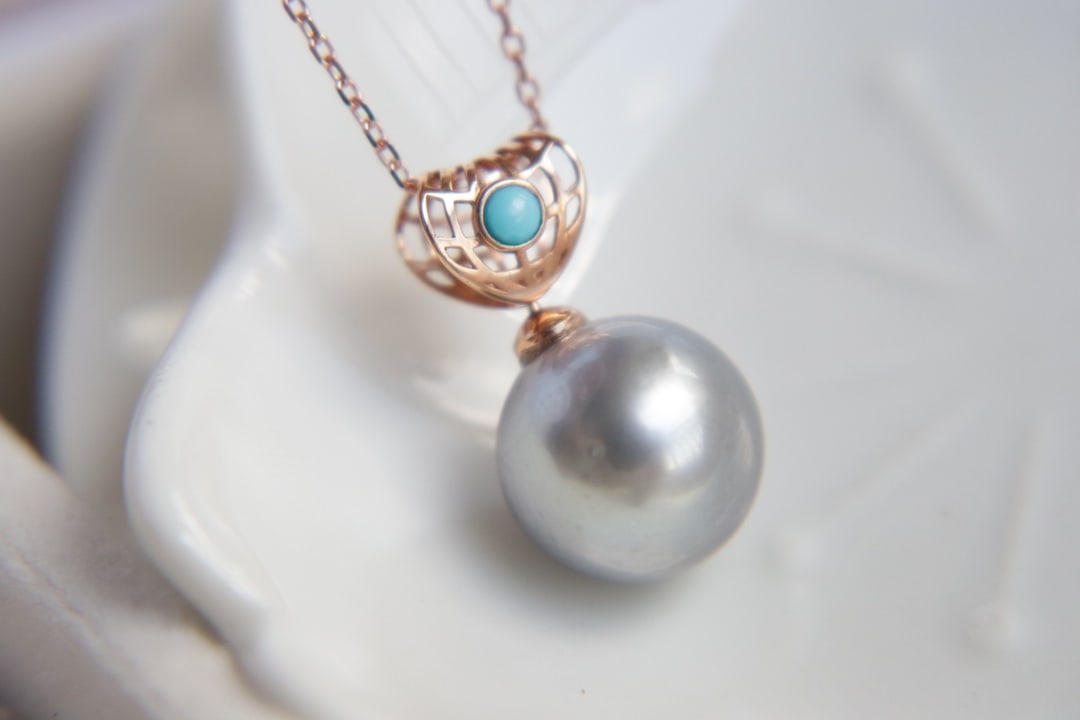 18K Gold Tahitian Pearl Pendant: This pendant is crafted from 18K gold, featuring a Tahitian pearl that exudes natural luster and elegance. The pearl measures 11.9mm in diameter, with a perfect round shape and flawless surface, exhib