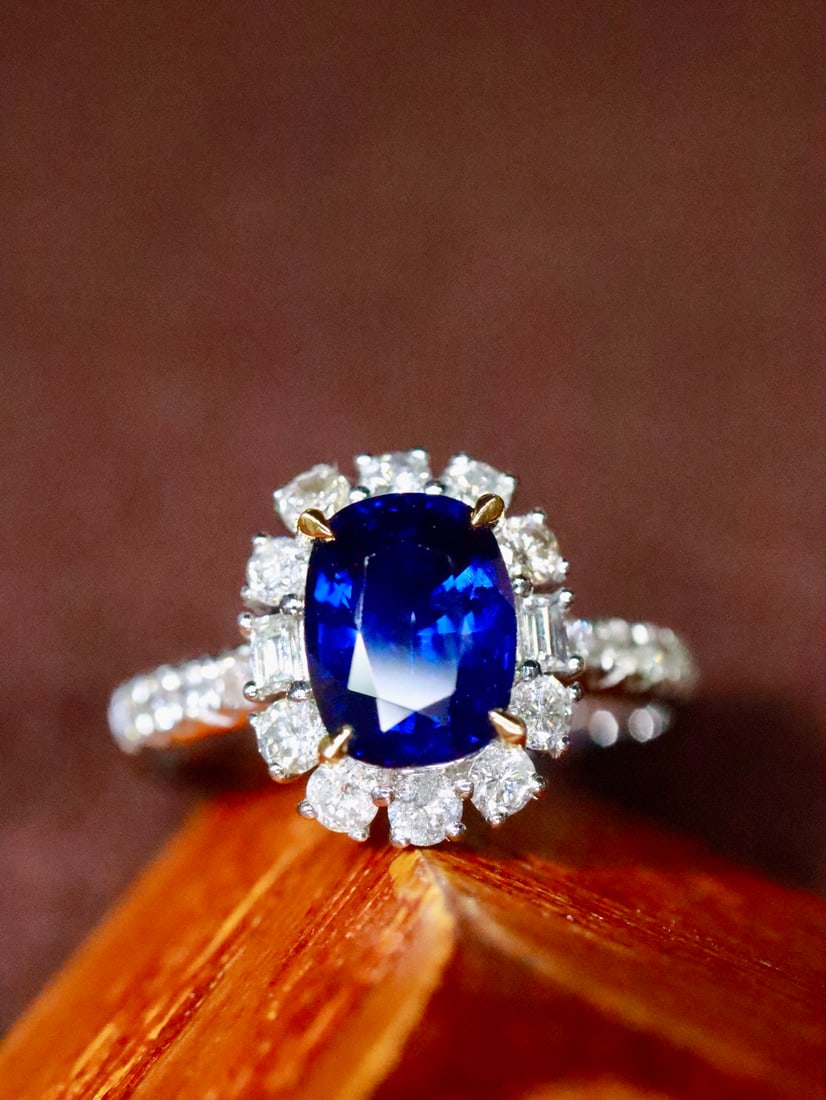 18K Gold Natural Sapphire Ring: This ring features a classic cushion-cut sapphire as the main stone, showcasing deep color and excellent clarity. Paired with round diamonds, the design is simple yet luxurious. (Main stone 1.62