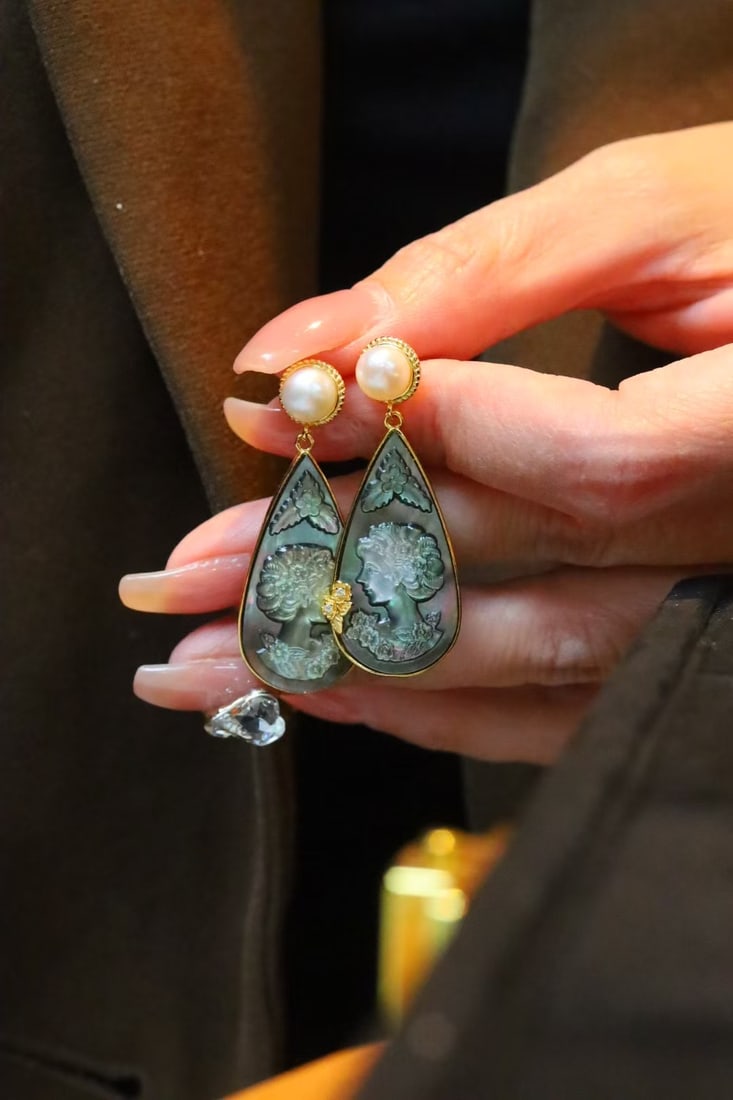 Natural Black Mother-of-Pearl Earrings: These earrings feature natural black mother-of-pearl, intricately carved with a human head motif, exuding a unique artistic aura. The silver gilding process enhances its luster and durability. Freight