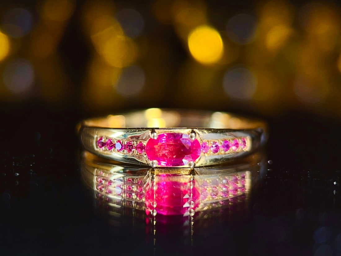 18K Gold Natural Ruby Ring: This ring is meticulously set in 18K gold, showcasing the noble and elegant nature of the ruby. The main ruby stone has a rich hue, complemented by delicately set side stones, creating an elegant and