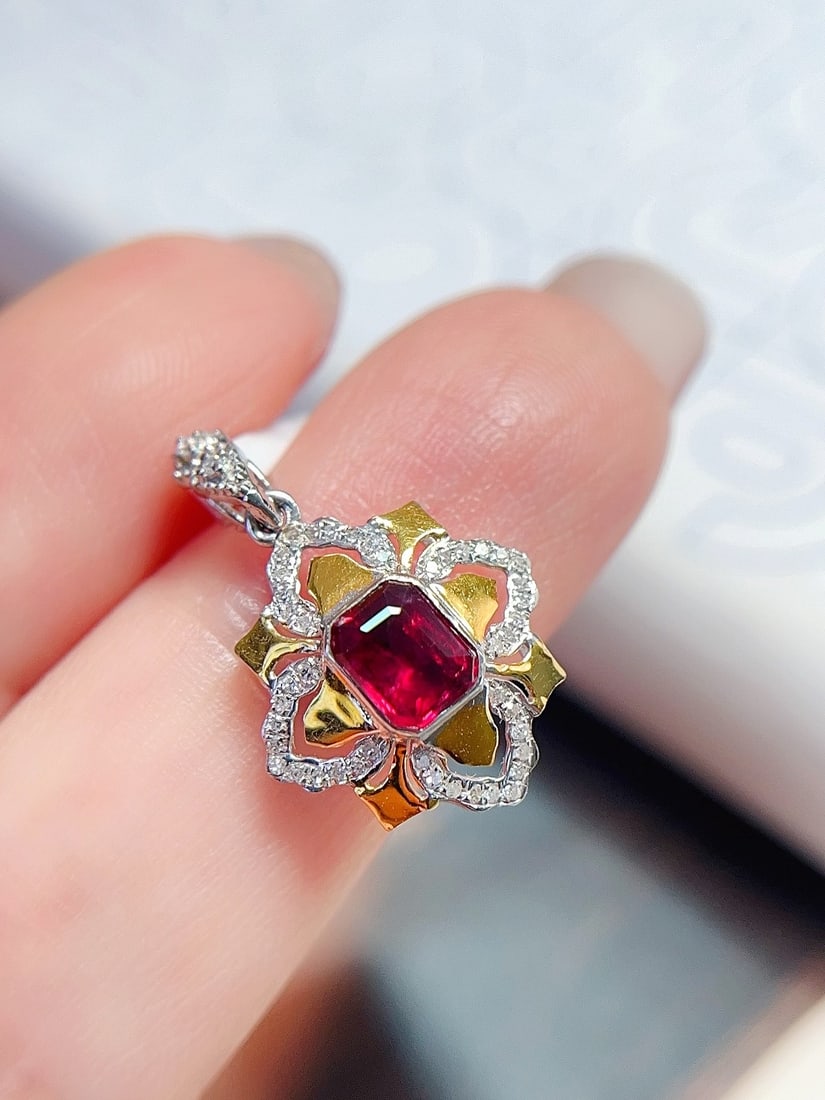 18K Gold Pigeon Blood Red Ruby Pendant: This pendant is meticulously crafted in 18K gold, featuring a pigeon blood red ruby with a classic emerald cut style. The vintage design is enhanced by the brilliance of 46 diamonds, adding an unparal