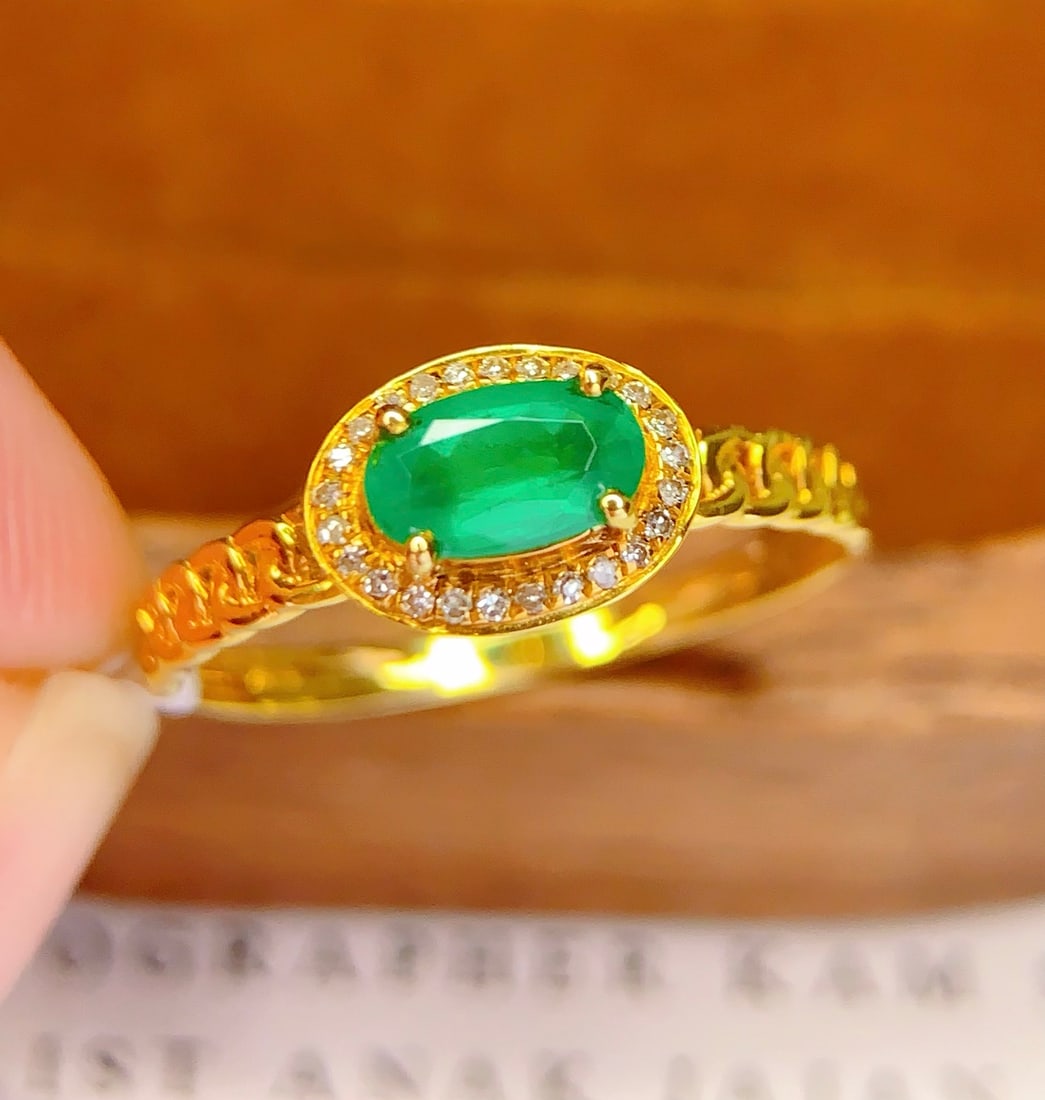 18K Gold Natural Emerald Ring: This 18K gold ring is set with a natural emerald, exuding an aura of elegance and nobility. The exquisite craftsmanship and design make it a precious collectible. The ring is also adorned with 25 diam