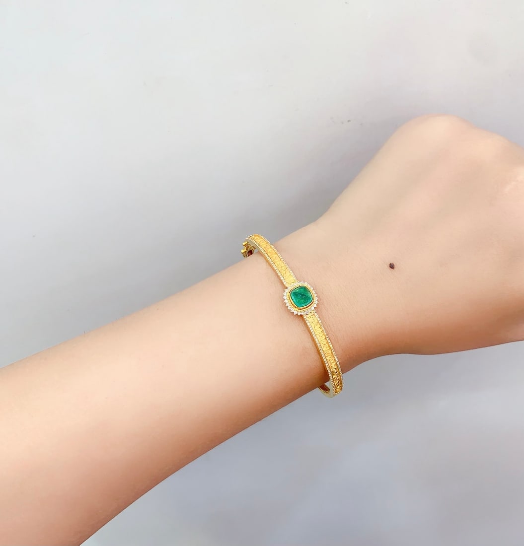 18K Gold Natural Emerald Bracelet: This bracelet is meticulously crafted in 18K gold, set with a natural emerald that exudes an aura of elegance and nobility. The main emerald stone weighs 2 carats, surrounded by 190 sparkling diamonds