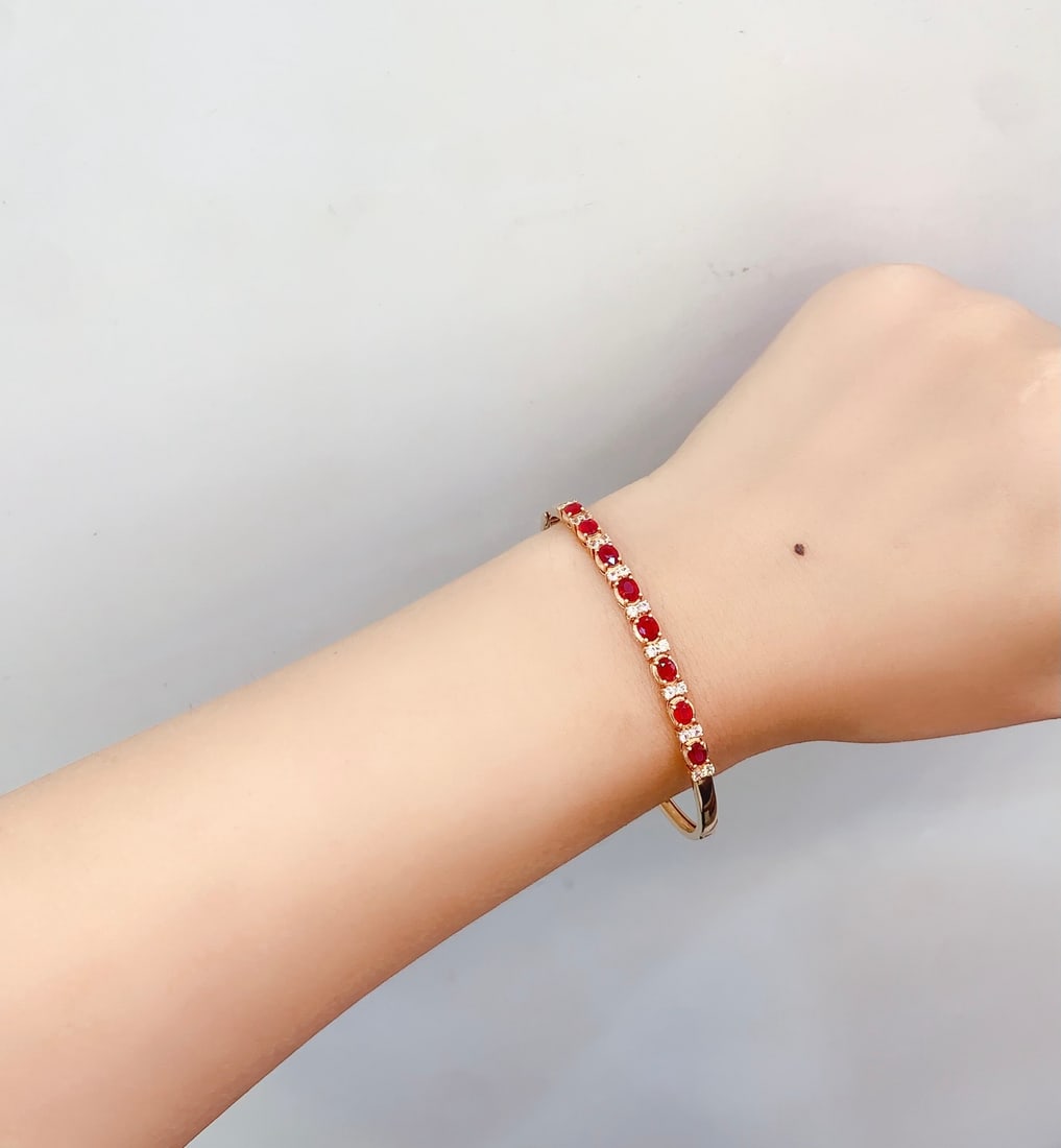 18K Gold Natural Ruby Bracelet: This bracelet is meticulously crafted in 18K gold, set with a natural ruby, exuding an aura of elegance and nobility. The main stone is a 2.5-carat ruby, surrounded by 18 colored gemstones, creating a