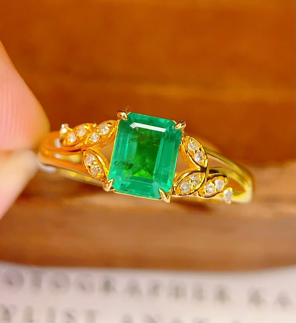 18K Gold Natural Emerald Ring: This ring is crafted from 18K gold and set with a natural emerald, exuding an elegant and noble aura. The main stone is a 1.10-carat emerald, surrounded by 14 diamonds that add a brilliant sparkle. Th
