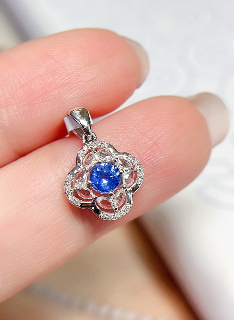 18K Gold Sapphire Pendant: This pendant is meticulously crafted in 18K gold, featuring an approximately 0.35-carat sapphire that exudes enchanting colors. Surrounded by 20 diamonds and 8 white sapphires, the design is elegant a