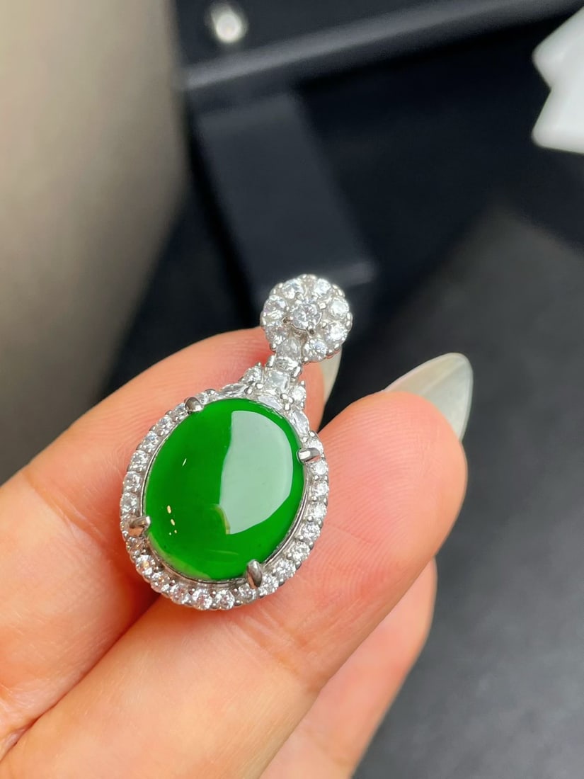 Silver Full Green Jadeite Pendant: This jadeite pendant showcases a full green hue, with a lustrous and perfect appearance. Its design is simple yet elegant, suitable for various occasions. (Stone size 15*12mm) Freight: 1.International
