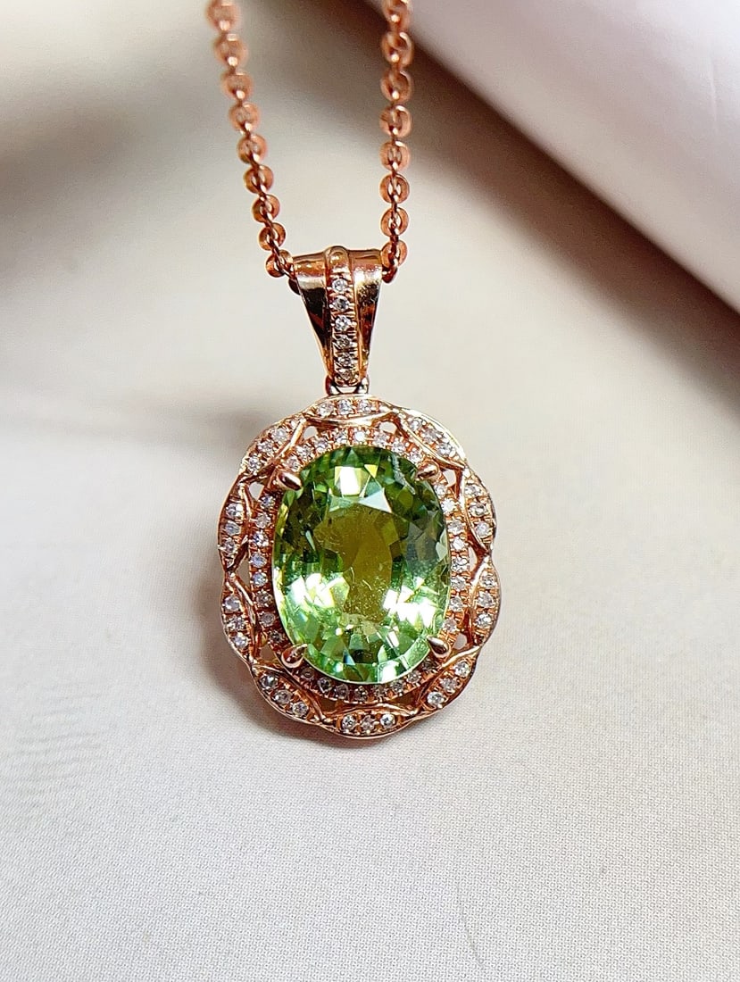 18K Gold Tourmaline Pendant: This pendant is meticulously crafted in 18K gold, showcasing the unique allure of glassy green tourmaline. Its classic and elegant design captivates at first sight, complemented by 68 sparkling diamon