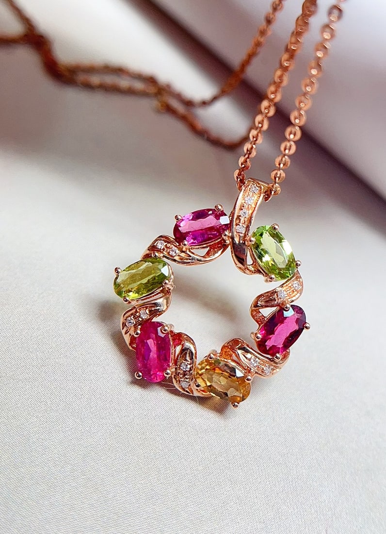 18K Gold Tourmaline Pendant: This pendant is meticulously crafted in 18K gold, showcasing the unique charm of tourmaline. The rainbow-colored glassy tourmaline, complemented by 14 diamonds, is designed with exquisite elegance. Pe
