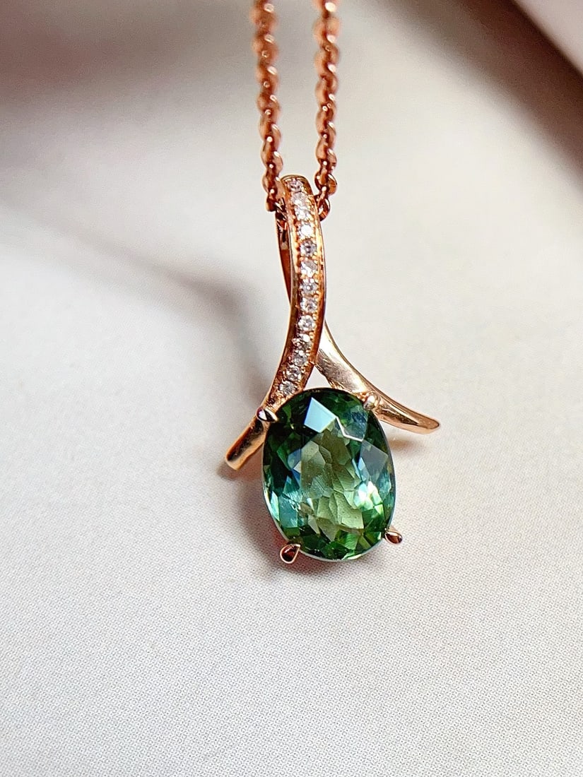 18K Gold Tourmaline Pendant: This pendant is crafted in 18K gold, featuring a glassy green tourmaline that exhibits dazzling brilliance. Its fresh and simple design makes it suitable for any occasion. The main stone is approximat