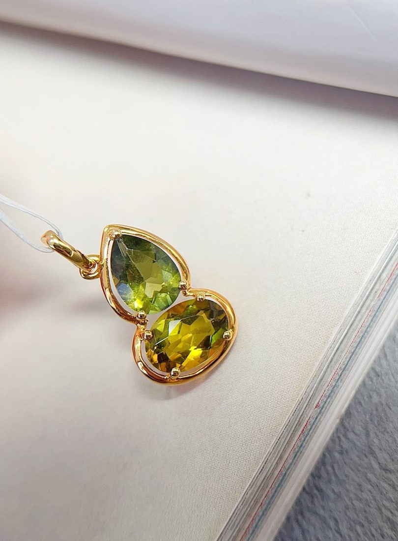 18K Gold Tourmaline Pendant: This pendant is crafted from 18K gold, showcasing an elegant minimalist style. The glassy green tourmaline shines like morning dew, captivating the beholder. The small gourd design adds a touch of pla