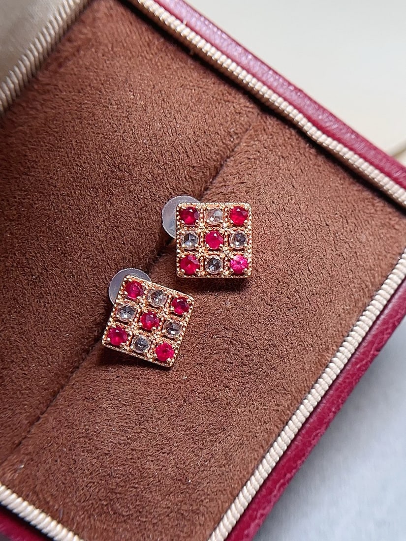 18K Gold Ruby Earrings: These earrings are crafted in 18K gold, featuring a ruby of approximately 0.38 carats with a classic pigeon blood red hue. Surrounded by 8 white sapphires, they add a brilliant sparkle to the design. 