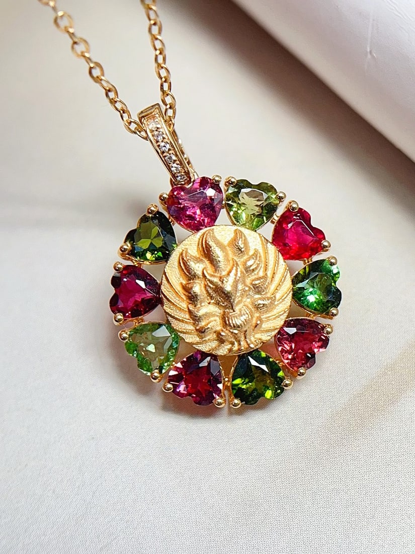 18K Gold Tourmaline Pendant: This pendant is crafted from 18K gold, featuring a heart-shaped tourmaline with a unique red and green hue. Its exquisite design makes it a captivating piece of jewelry. The embedded diamonds add a to