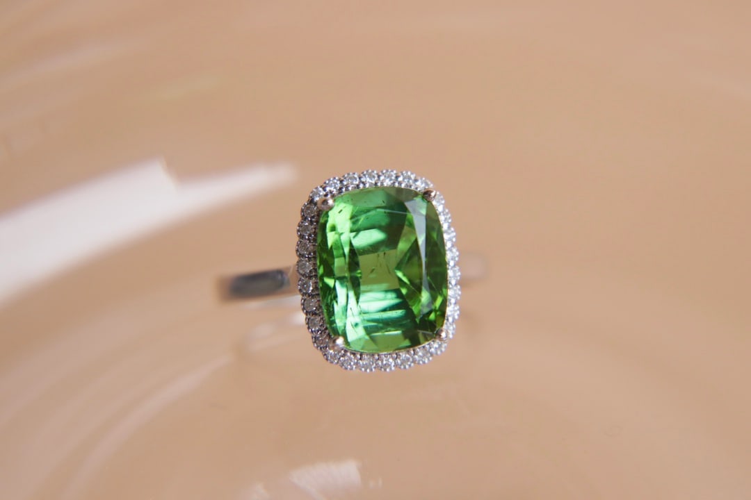 18K Gold Natural Green Tourmaline Ring: This ring is meticulously crafted in 18K gold, featuring an elegantly colored green tourmaline, showcasing a simple yet grand style. Adorned with South African diamonds, it adds a brilliant sparkle. (
