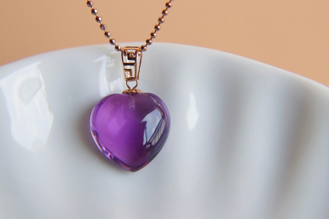18K Gold Natural Amethyst Pendant: This pendant is meticulously crafted in 18K gold, set with a natural amethyst, exuding a noble and elegant aura. The deep and enchanting hue of the amethyst perfectly complements the wearer's