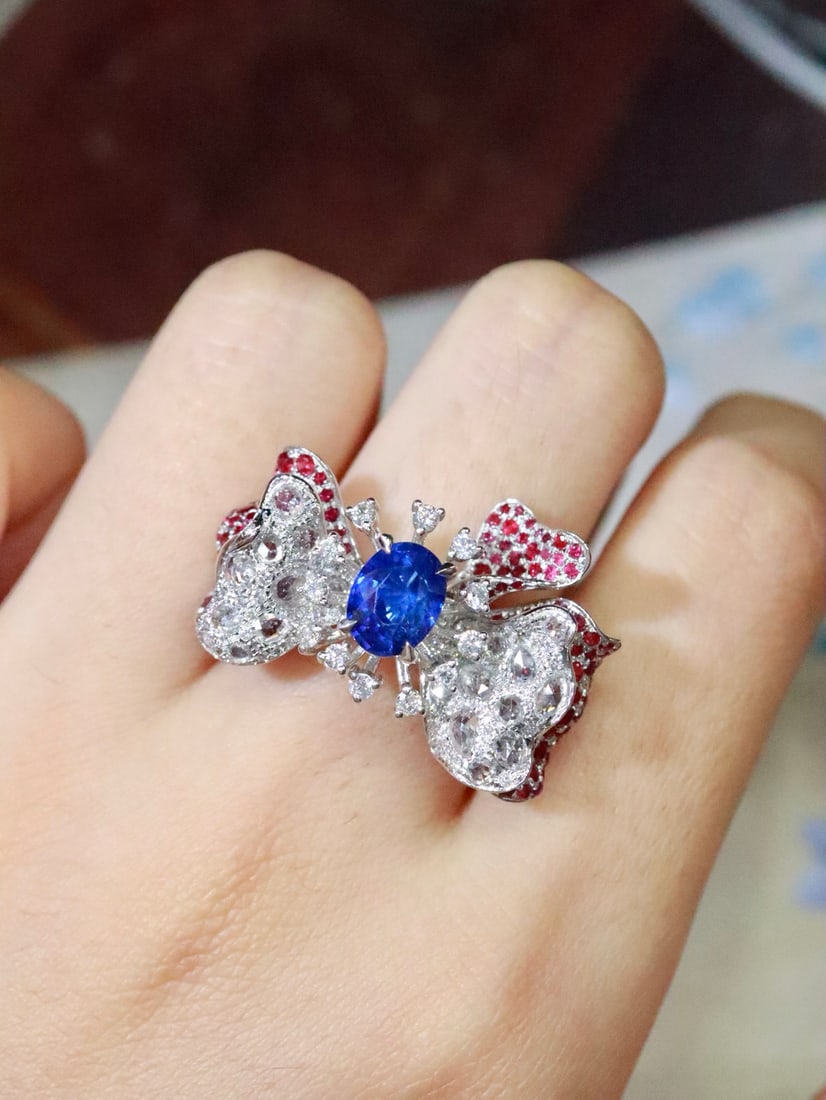 Platinum Natural Sapphire Ring: This ring features a unique and elegant design with naturally curved petal shapes. The rich sapphire main stone complements the sparkling diamonds, with rubies adding a touch of luxury. The overall de