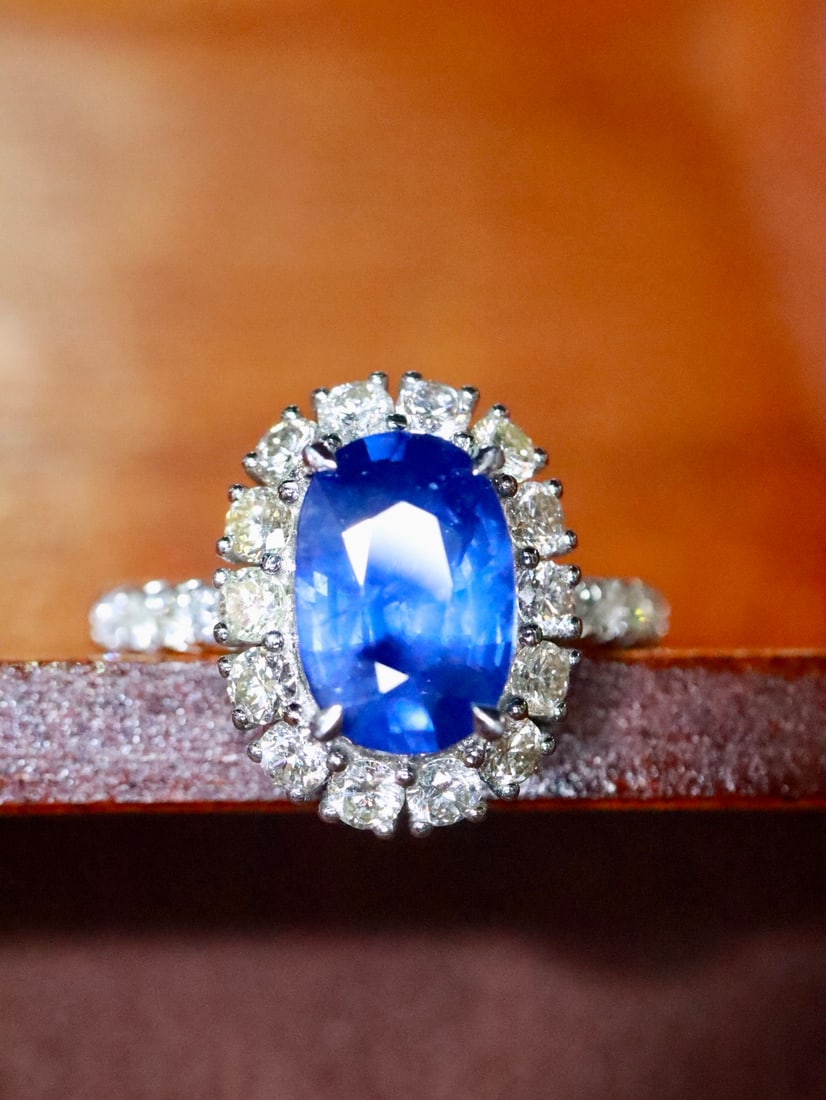 Platinum Natural Sapphire Ring: This ring is meticulously set in platinum, featuring a 2.6-carat sapphire with a rich and captivating hue. Surrounding diamonds total 0.93 carats, adding a brilliant sparkle. The total gold weight is 