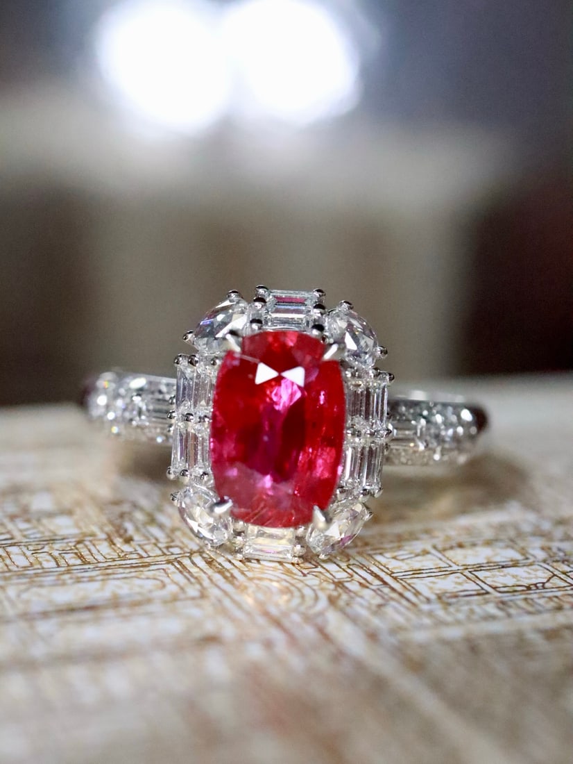 Platinum Natural No-Heat Ruby Ring: This ring features a no-heat oval ruby at its center, radiating a fiery and vivid hue. Surrounding it are meticulously arranged diamonds, resembling twinkling stars, creating a harmonious brilliance t