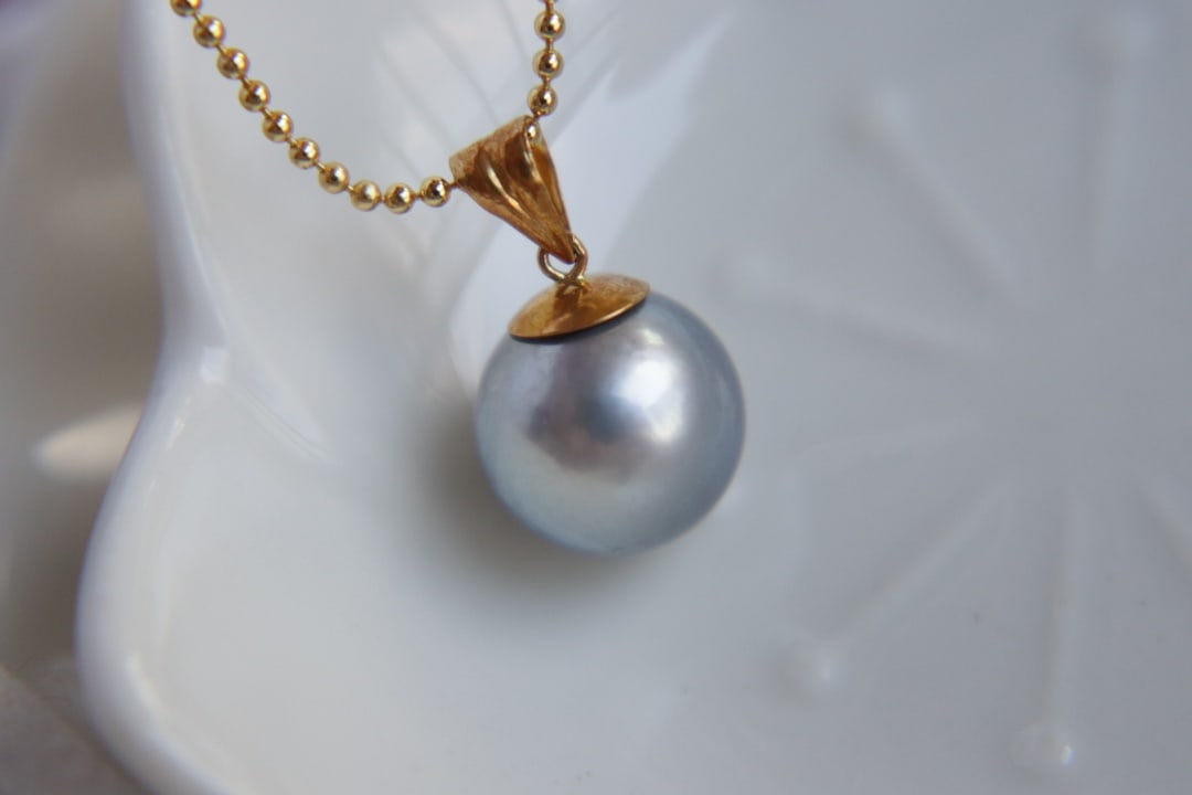 18K Gold Tahitian Saltwater Pearl Pendant: This pendant is crafted from 18K gold, featuring a Tahitian saltwater pearl that exudes natural luster and elegance. The pearl measures 11mm in diameter, with a perfect round shape and flawless surfac