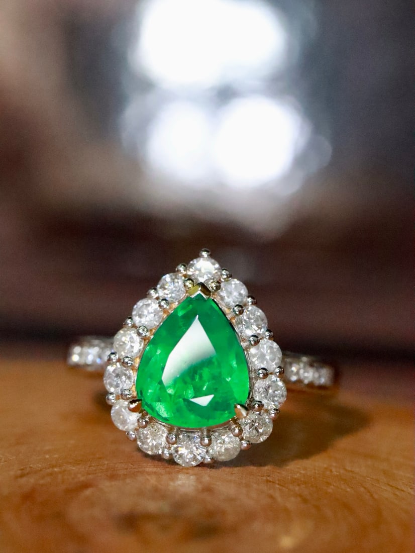 18K Gold Natural Emerald Ring: This emerald ring exudes elegance and nobility, with a richly colored and flawless main stone. Set in an 18K gold band, it embodies luxury. (Main stone 1.35 carats, side stones 0.868 carats, total wei
