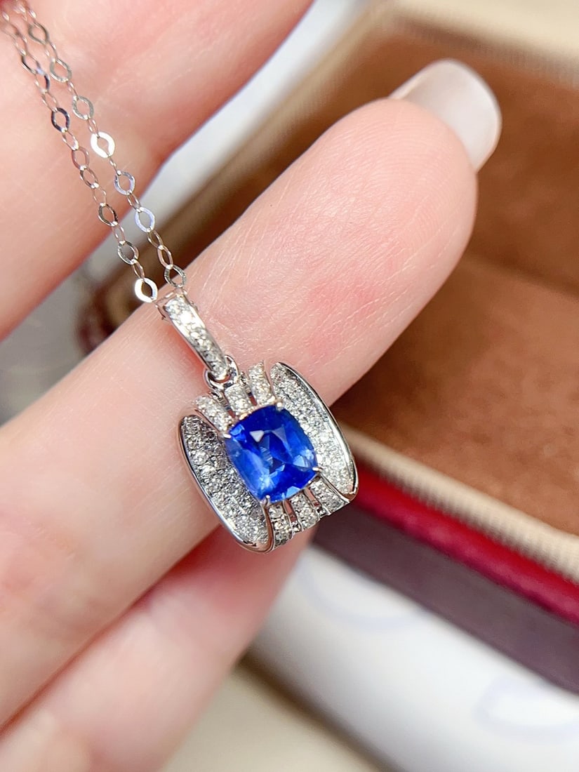 18K Gold Sapphire Pendant: This pendant is meticulously crafted in 18K gold, featuring a bright sapphire with a cornflower-like hue, pure and flawless. Accented with diamonds, it adds a touch of luxury. (Main stone approx.