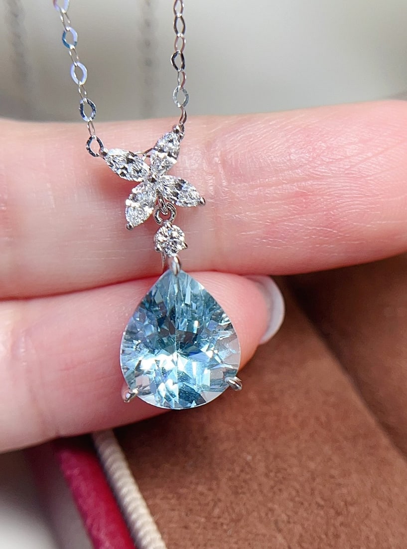 18K Gold Aquamarine Pendant: This pendant is meticulously crafted in 18K gold, featuring a brilliant aquamarine that exudes a simple yet elegant design. The glassy texture of the main stone complements its dazzling fire, making