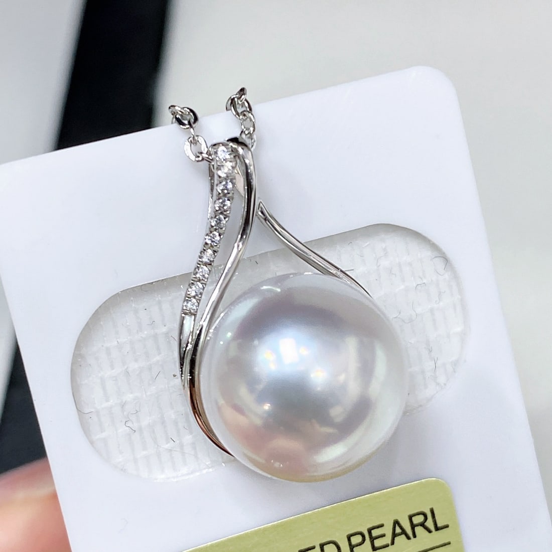 18K Gold Perfectly Round Australian White Pearl Pendant: This pendant features a perfectly round Australian white pearl measuring 12-13MM, showcasing a satin-like pink luster. The 18K gold fittings add a touch of luxury to the pearl, with a design that is
