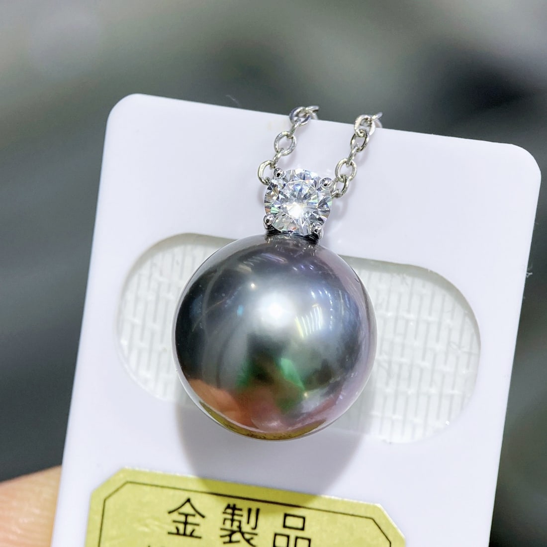18K Gold Tahitian Pearl Pendant: This pendant features a Tahitian pearl, exuding a calm and noble aura. The slightly blemished nature of the pearl adds to its natural beauty, complemented by a thick 18K gold clasp, showcasing luxury.