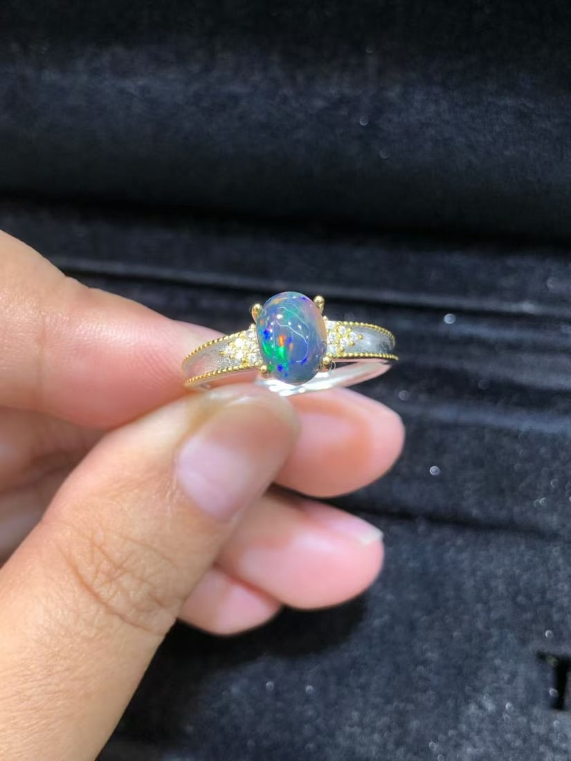 Natural Black Opal Ring: This natural black opal ring captivates every wearer with its unique colors and luster. The main stone measures 6*8mm, showcasing the enchanting charm of black opal, complemented by exquisite S925