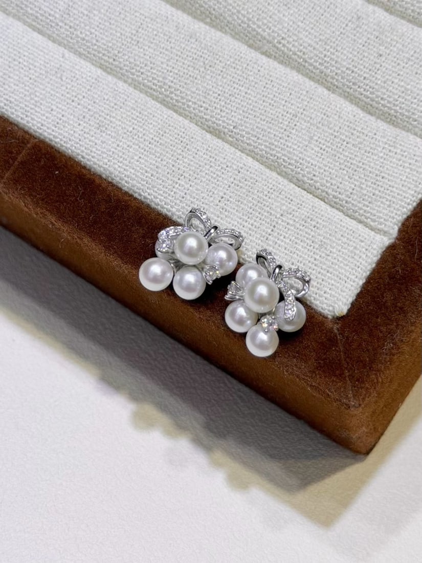 Natural Freshwater Pearl Earrings: These earrings feature natural freshwater pearls, showcasing an elegant round shape and strong luster. The pearls are nearly flawless, paired with pure silver fittings, exuding a simple yet noble char