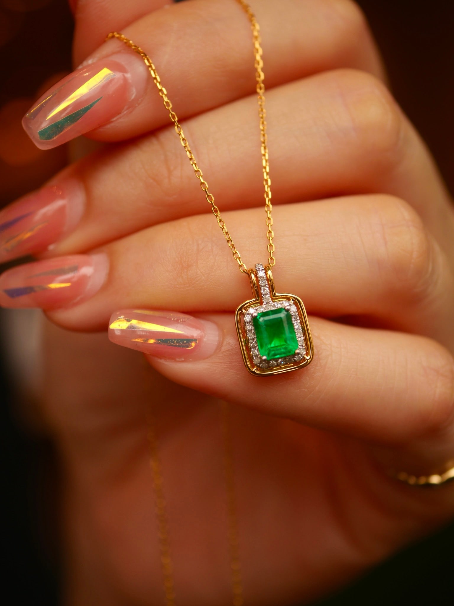 18K Gold Natural Emerald Pendant: This pendant is meticulously crafted in 18K gold, set with a natural emerald that exudes an aura of elegance and nobility. The deep and captivating hue of the emerald is truly irresistible. Whether fo