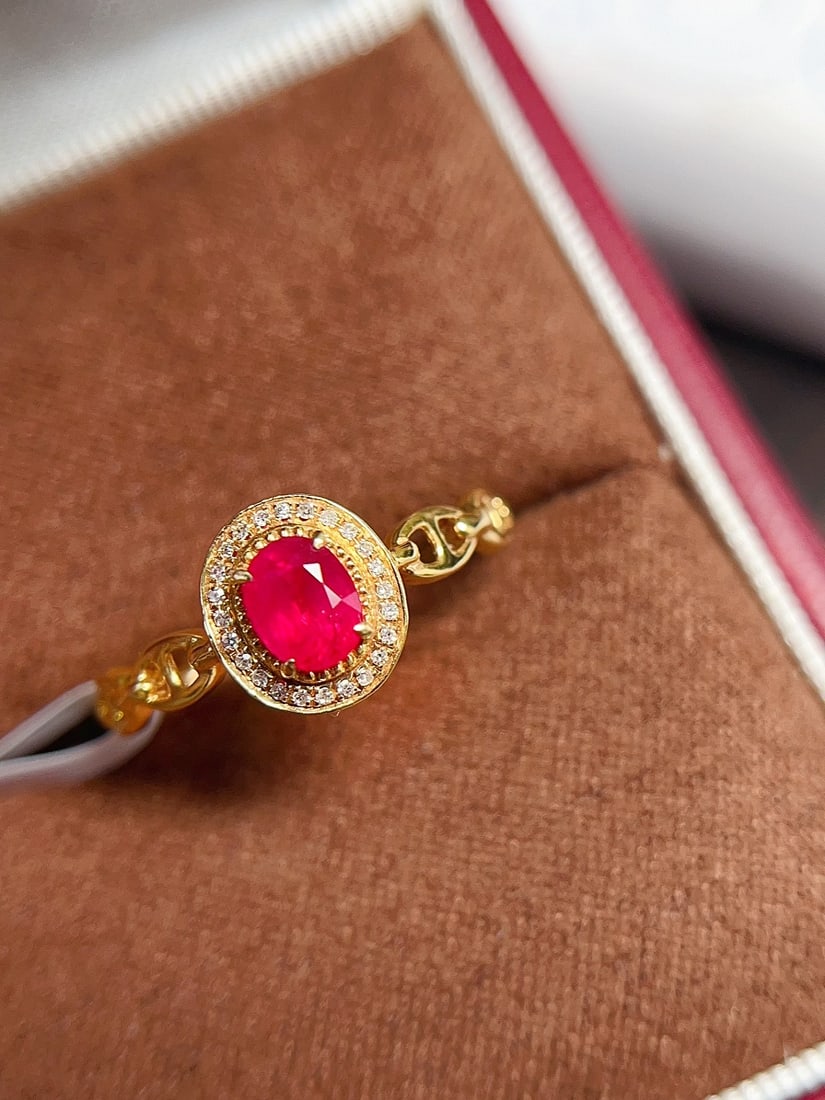 18K Gold Pigeon Blood Ruby Ring: This ring is meticulously crafted in 18K gold, featuring a richly colored pigeon blood ruby, exuding an elegant vintage style. The ruby's clarity and lack of fractures enhance its value, while 24 surr