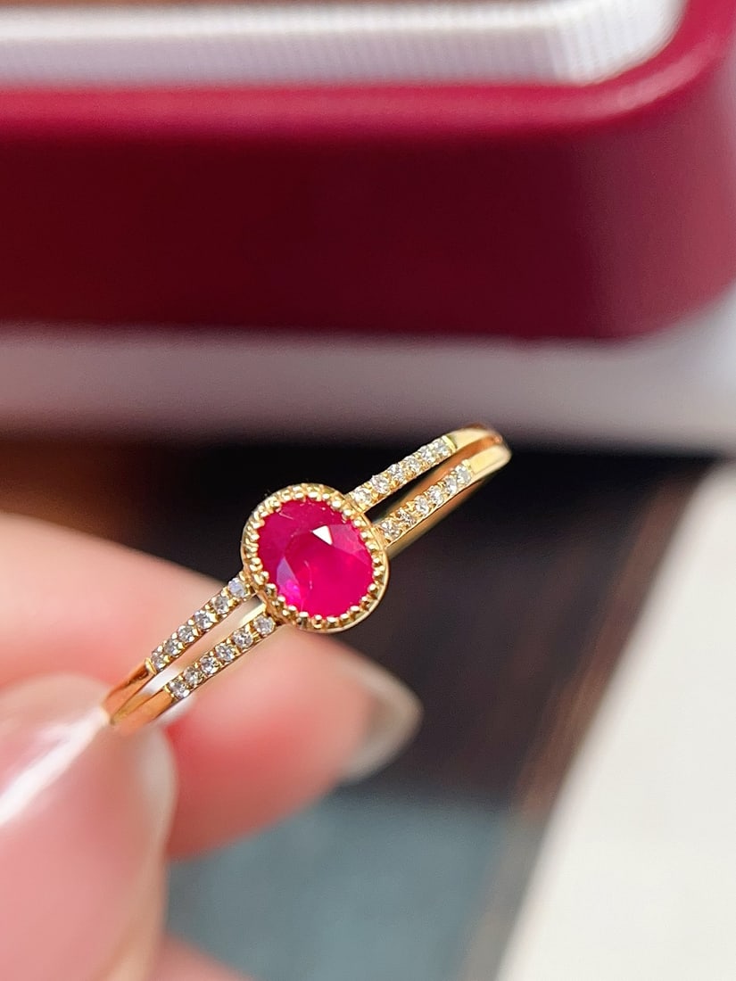 18K Gold Pigeon Blood Red Ruby Ring: This ring is crafted from 18K gold, featuring a richly colored pigeon blood red ruby. Its minimalist design exudes elegance, with 24 diamonds surrounding the main stone, adding a dazzling brilliance. 