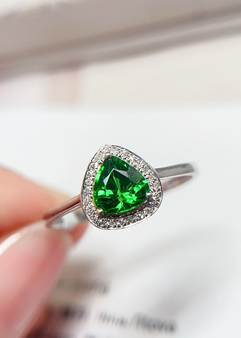 18K Gold Tsavorite Ring: This ring is meticulously crafted in 18K gold, showcasing the spicy green hue of the flawless tsavorite, reminiscent of pure glass. The brilliant fire complements the 24 diamonds, captivating the eye.