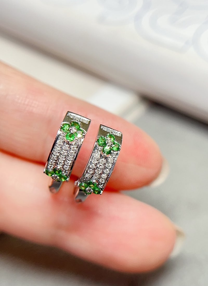 18K Gold Tsavorite Earrings: These earrings feature a fresh clover design, showcasing a simple yet elegant style. Set with 34 diamonds, they add a dazzling brilliance. Suitable for various occasions, exuding noble charm. (Main st