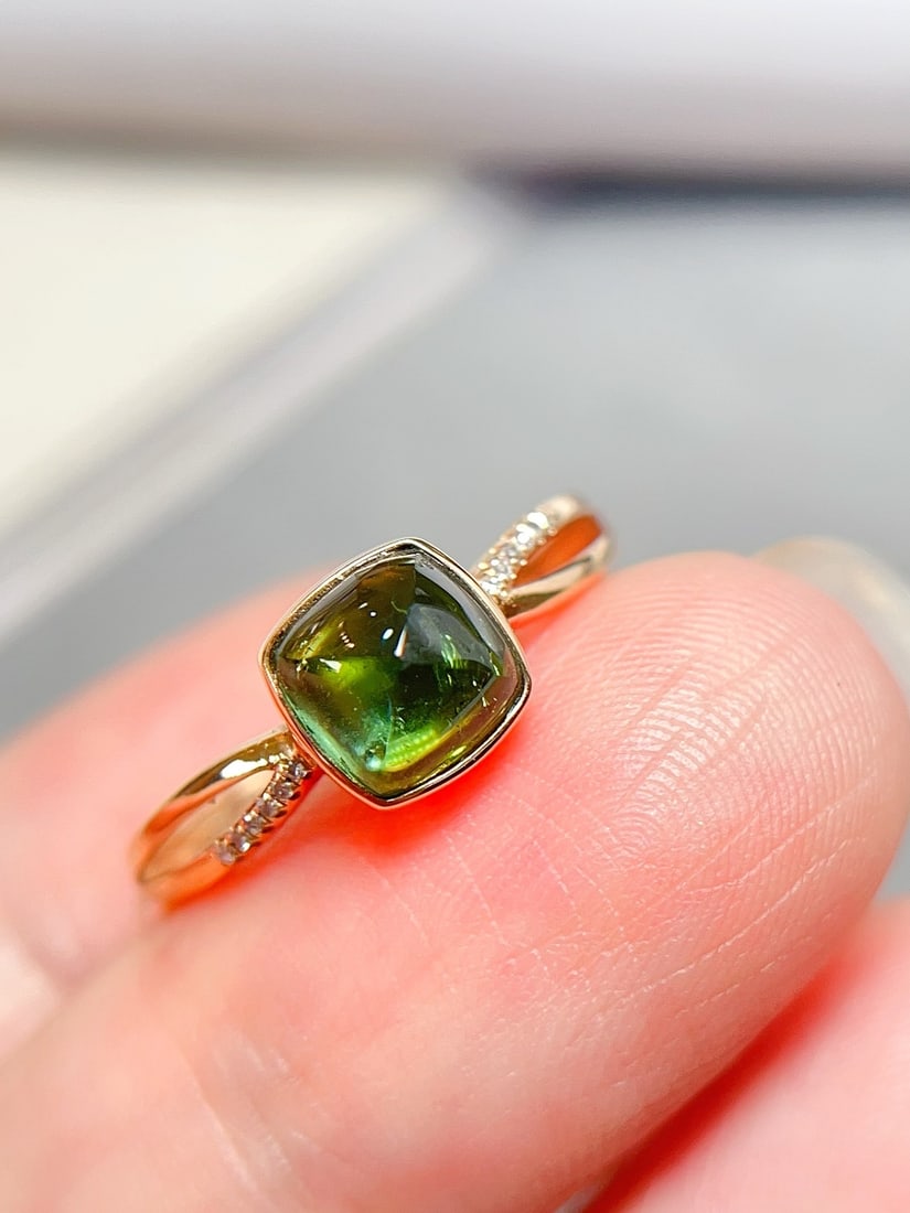 18K Gold Natural Tourmaline Ring: This ring is meticulously crafted in 18K gold, featuring a richly colored tourmaline that exhibits a captivating fluorescent effect. The main stone is clear and flawless, complemented by 12 sparkling 