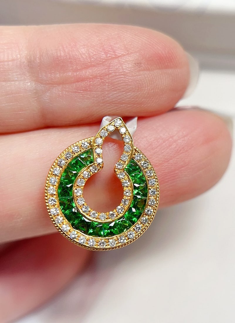 18K Gold Tsavorite Pendant: This pendant is meticulously crafted in 18K gold, showcasing a unique vivid green color. The bezel-free setting and the central gourd shape add a touch of design flair. The overall style is fashionabl